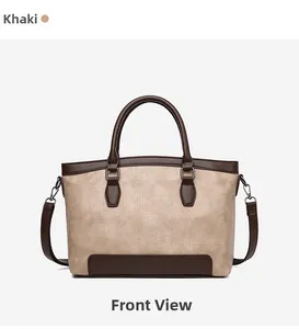 Detail of khaki crocodile pattern leather handbag with dark brown trim and dual ring handles