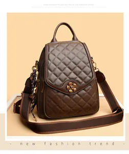 Close-up of brown quilted backpack with a bronze plum blossom lock and woven strap