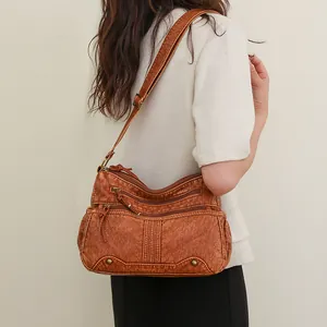 Vintage brown washed leather crossbody bag with multiple zippers and adjustable strap