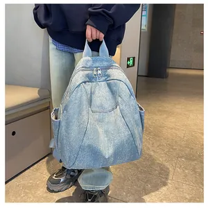 Close-up of light blue denim backpack featuring metal zippers and front pocket details