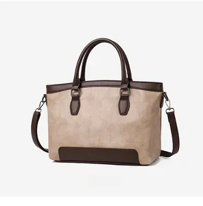 Detailed 45-degree angle view of an apricot stone-pattern leather handbag with dual handles