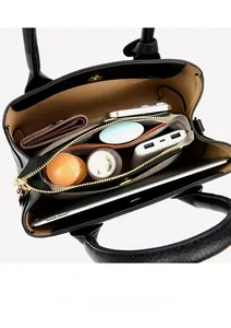 Detail view of black pebble leather tote interior with compartments and various daily items