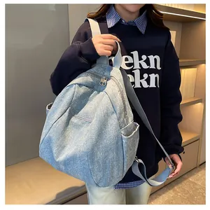 Detail of vintage blue denim backpack with punk rivet accents and adjustable straps