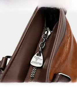 Macro shot of silver zipper with kangaroo logo on textured brown leather bag
