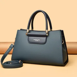 Sac à main en cuir gris-bleu avec détails dorés et bandoulière amovible élégant