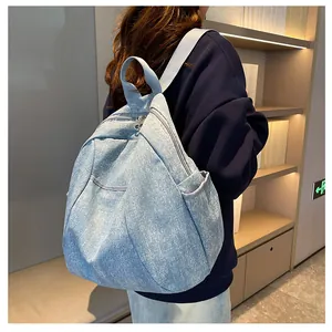 Detail of light blue denim backpack with white star pattern on a model in a library