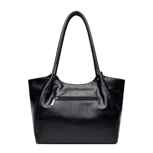 Classic black crocodile embossed leather tote bag with long shoulder straps on white background