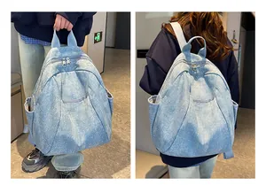 Detailed view of light blue denim backpack with dual zippers and side pockets in use