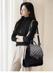 Close-up of quilted leather backpack with gold flower lock and striped shoulder strap