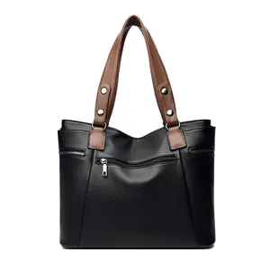Classic black leather tote bag with brown handles and front zipper detail for women