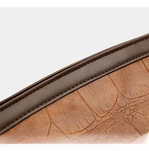 Macro detail of brown crocodile embossed leather with precise double stitching on the handbag