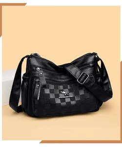 Dettaglio della borsa a tracolla nera con texture litchi e scomparti con zip multistrato