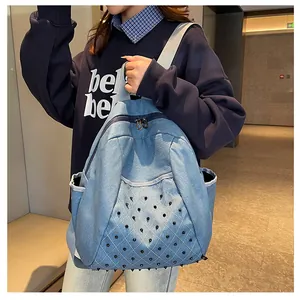 Detail of denim backpack showing quilted pattern with punk-style metal conical studs