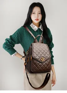 Close-up of quilted leather backpack featuring gold floral lock and woven side charm