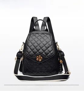 Detail of black quilted leather backpack with golden flower lock and textured finish