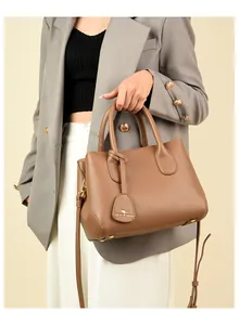 Close-up of brown litchi pattern leather handbag with kangaroo charm and gold hardware