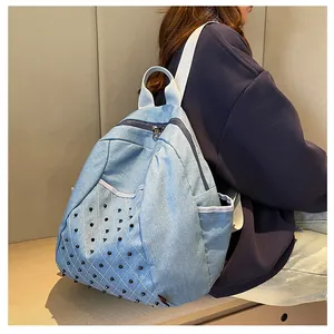 Detailed side view of denim backpack with black punk studs and quilted texture