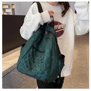 Detail of dark green denim backpack featuring punk studs and classical bamboo patterns