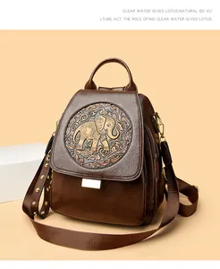 Detalle de mochila vintage de cuero marrón con patrón de elefante en relieve y remaches de metal
