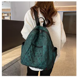 Detail of green backpack featuring bamboo leaf print and punk-style metal cone rivets