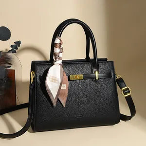 Elegant black litchi grain leather handbag with gold lock and decorative silk scarf
