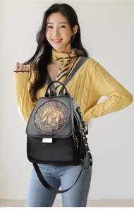 Detalle de mochila de cuero vintage con relieve de elefante y herrajes metálicos dorados
