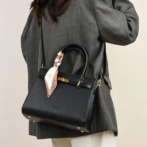 Elegant black lychee grain leather handbag with gold hardware and decorative silk scarf