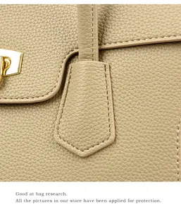 Detail of premium beige pebbled leather texture and gold buckle on Kelly style handbag