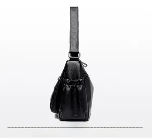 Dettaglio borsa a tracolla in pelle nera con tasca laterale elastica e cerniera metallica