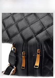 Detailed macro view of black quilted leather texture and vintage gold zipper hardware