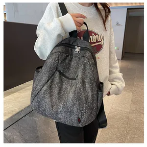 Detail of grey polka dot backpack featuring dual zippers and durable woven fabric texture
