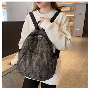 Detail view of denim backpack with star pattern and sturdy black shoulder straps