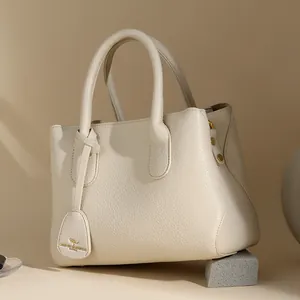 Elegant beige leather tote bag with pebble texture and gold kangaroo charm detail