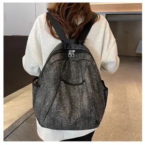Detailed back view of grey star-pattern denim backpack with adjustable shoulder straps
