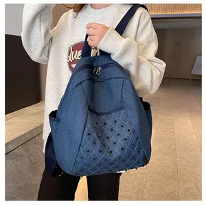 Detail view of denim backpack featuring quilted pattern and punk style cone rivets