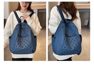 Detail view of denim backpack featuring black rivet diamond pattern and fabric straps
