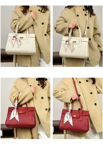 Detailed view of leather handbags with turn-lock clasp and decorative silk scarves