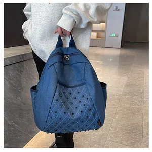 Close-up of punk style blue denim backpack with metallic studs and side pocket detail
