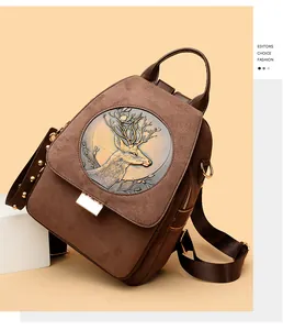 Detailed view of sika deer embossment and studded strap on vintage suede backpack