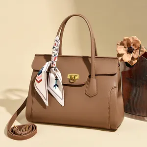 Elegant brown pebble leather handbag with gold twist lock and stylish silk scarf detail