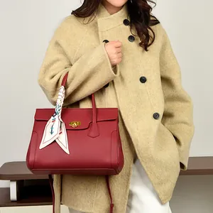 Elegant wine red leather handbag with gold twist lock and decorative silk scarf handle