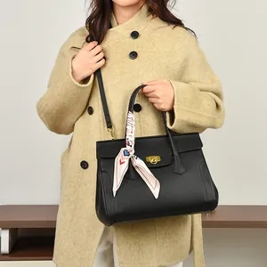 Elegant black lychee leather handbag with gold lock and decorative silk scarf detail