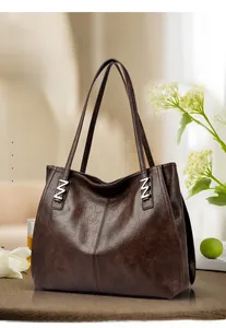 Close-up of vintage texture on dark brown leather tote with metal hardware accents