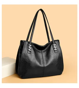 Detail of black leather tote bag featuring elegant silver N-shaped metal hardware accents