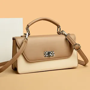 Elegante bolso bandolera bicolor en crema y marrón con cierre de giro plateado texturizado
