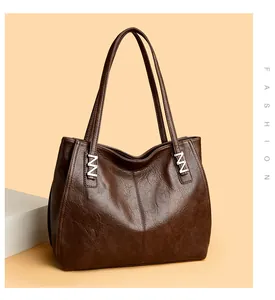 Detailed close-up of dark brown tote bag with premium leather grain and silver metal clasp