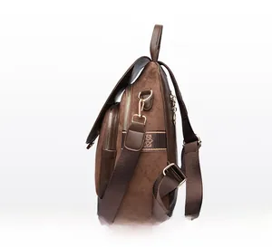 Side view of brown suede backpack showing multiple zipper compartments and textured strap