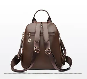 Detail of dark brown faux suede backpack with anti-theft back pocket and kangaroo charm