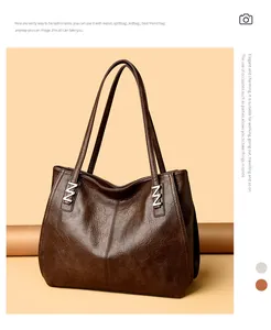 Detailed view of dark brown genuine leather tote featuring silver Z-shaped hardware