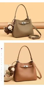 Close-up of litchi-textured leather bucket bags with metal buckles and monkey charms